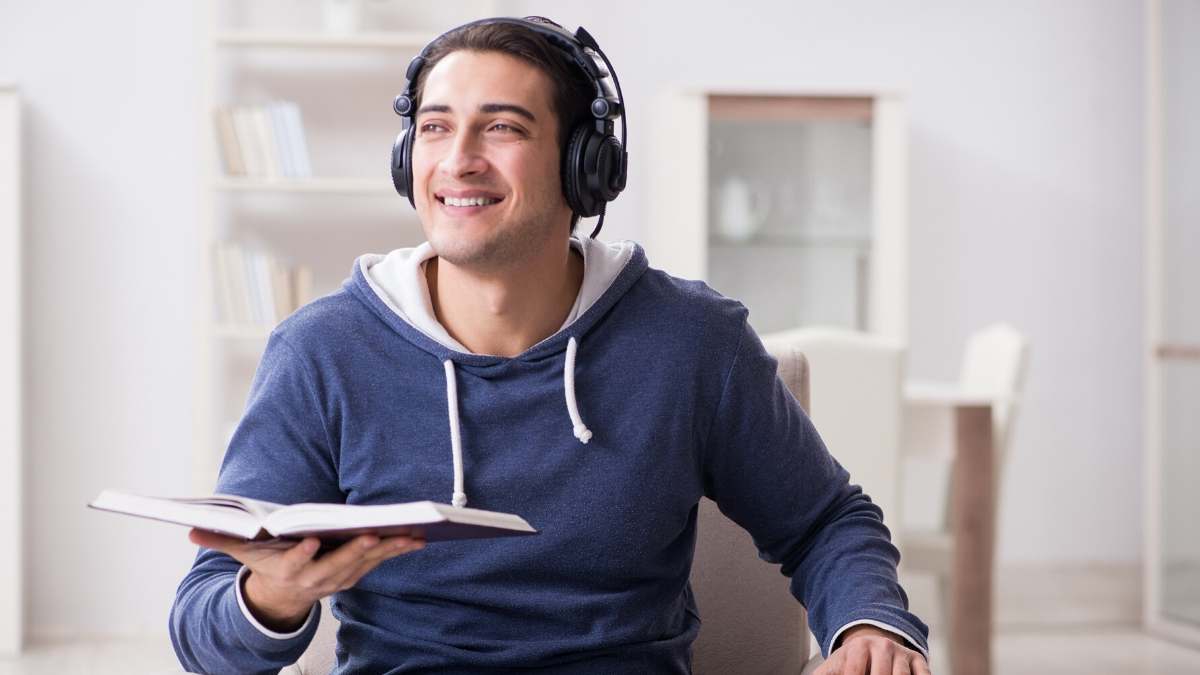 A man is listening to an audiobook using headphones.